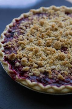 a pie sitting on top of a table covered in crumbs