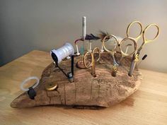 a wooden table topped with lots of scissors and other items on top of each other