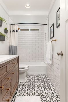 a white bathroom with black and white floor tiles