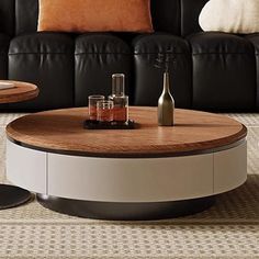 a living room with black leather couches and round coffee table