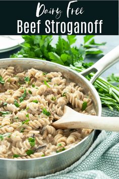 a pot filled with pasta and parsley on top of a blue towel next to green beans