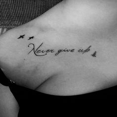 a woman's chest with the words never give up written on her left side