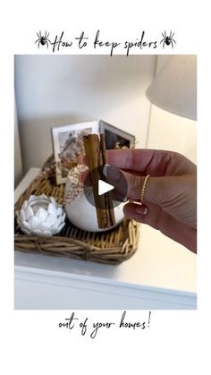 a person holding up a ring in front of a basket with flowers and pictures on it