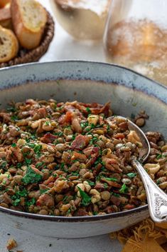 a large bowl filled with food next to bread