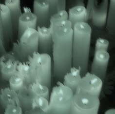 many white candles are lined up in rows