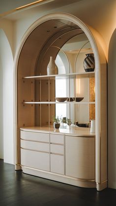 an arched doorway with shelves and vases on it's sides in a room