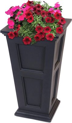 a black planter with red and pink flowers in it