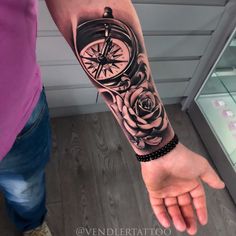 a person with a tattoo on their arm holding a clock and roses in the middle