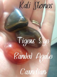 some kind of rock in someone's hand with the words tiger's eye carved agate canadian on it