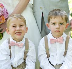 two young boys wearing suspenders and bow ties sitting next to each other in front of a bride