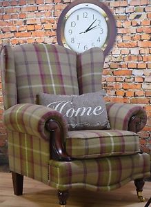 a plaid chair with a clock on the wall behind it