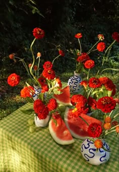 watermelon and carnations in vases on a table