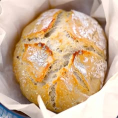 a loaf of bread sitting in a paper bag on top of a blue and white plate