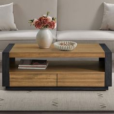 a living room with a couch, coffee table and vase on the end shelf in front of it