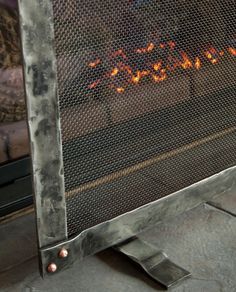 a fire burning in a fireplace next to a metal frame with the word love written on it