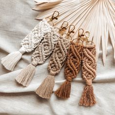 four tasseled key chains on top of a white cloth