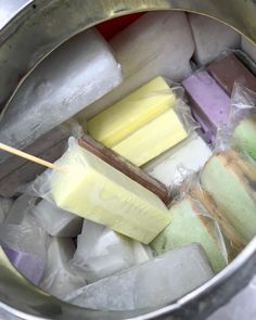 an ice bucket filled with lots of different types of popsicles and marshmallows