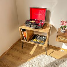 a record player is sitting on top of a wooden table next to a bookcase