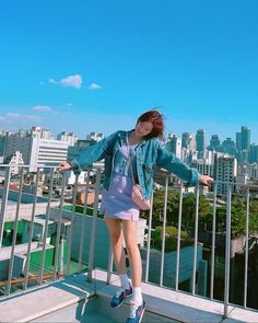 a woman standing on top of a metal railing