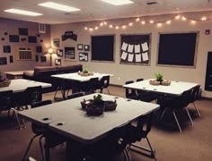 an empty classroom with desks, chairs and pictures hanging on the wall above them