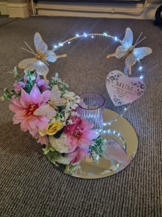 flowers and butterflies on a plate with lights in the shape of a heart for mum