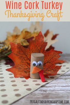 a turkey made out of toilet paper sitting on top of a table next to fall leaves