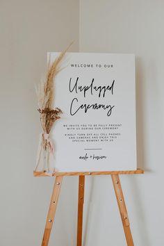 a welcome sign on an easel with dried flowers