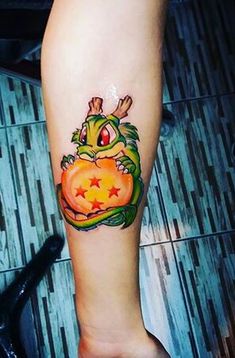 a person with a tattoo on their arm holding a pumpkin in the shape of a frog