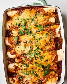 a casserole dish with meat, cheese and parsley on the top is ready to be eaten