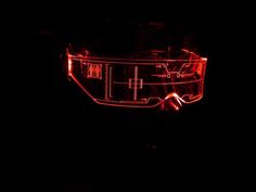 a red light shines on the side of a motorcycle helmet in the dark,