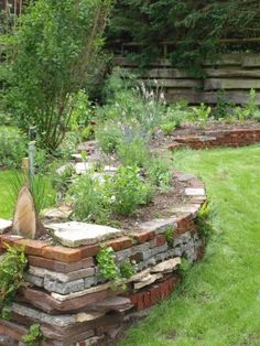 a garden with lots of green grass and plants in the center, surrounded by stone steps