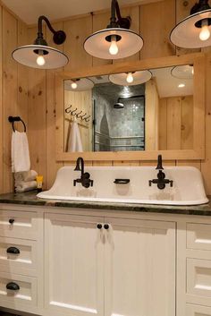 a bathroom with two sinks and three lights