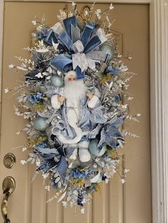 a blue and white christmas wreath on the front door with santa claus in his suit