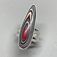 "Red, white and black-swirled Fordite talon with a long, lean shape and complementary swirly sterling silver band! This big guy packs a punch of style, and you can feel good about it because it's an upcycled material!! See more about Fordite below, but first the details of this piece of art jewelry.... The setting measures 1 7/8\" tall x 1/2\" wide, while the band is 1/4\" wide at the back and flares to about 1/2\" wide right under the stone. Super solid and comfortable to wear, and because Ford Fordite Ring, Fordite Jewelry, Jewelry Recycled, Big Ring, Automotive Paint, Bold Jewelry, Big Guy, Sterling Silver Bands, Silver Band