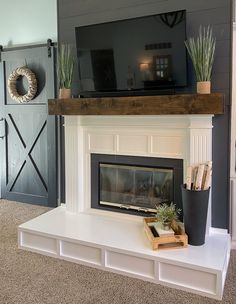 a living room with a fire place and television on top of the fireplace mantel