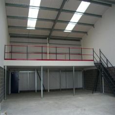 an empty garage with stairs leading up to the second floor