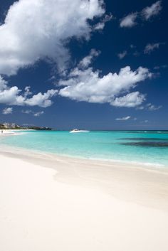 an empty beach with clear blue water and white sand