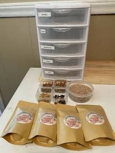 five bags of food sitting on top of a table next to some containers and spoons