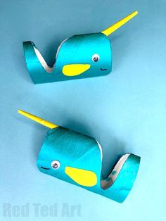 two blue and yellow whale shaped objects sitting on top of a blue surface with the words red ted art written below them