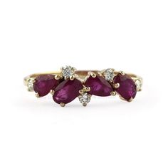 three stone ring in yellow gold with diamonds on each side and two pear shaped ruby stones at the top