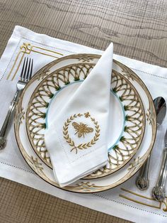 a white and gold place setting with silverware