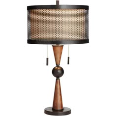 a lamp that is sitting on top of a wooden stand with a black and brown shade