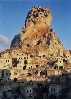 an old mountain with some buildings built into it