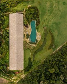 an aerial view of a house with a swimming pool in the middle of trees and grass