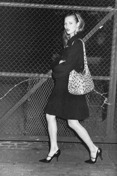 black and white photograph of a woman carrying a purse