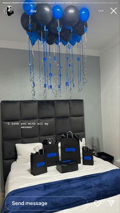 blue and black balloons hang from the ceiling above a bed