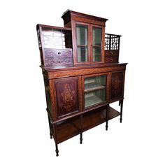 an old china cabinet with glass doors and drawers on it's sides, against a white background