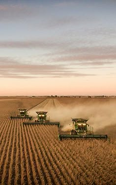 a group of farm machinery driving across a field