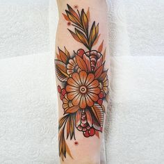 a woman's leg with an orange flower tattoo on her left arm and foot