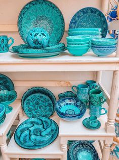 blue dishes and cups are on shelves in a room with other items, including plates